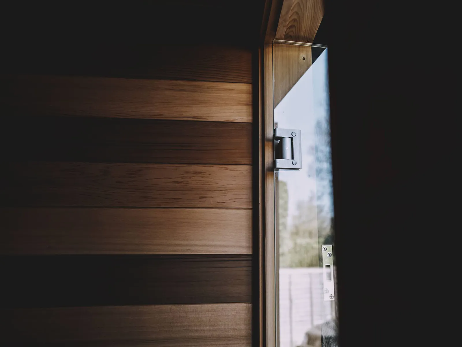 Glazed sauna door and specialist hinges Three Men relaxing outside a Wildhut outdoor Sauna